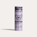 Purple cylindrical container of Butch Wrinkle Balm for dogs on a light purple background