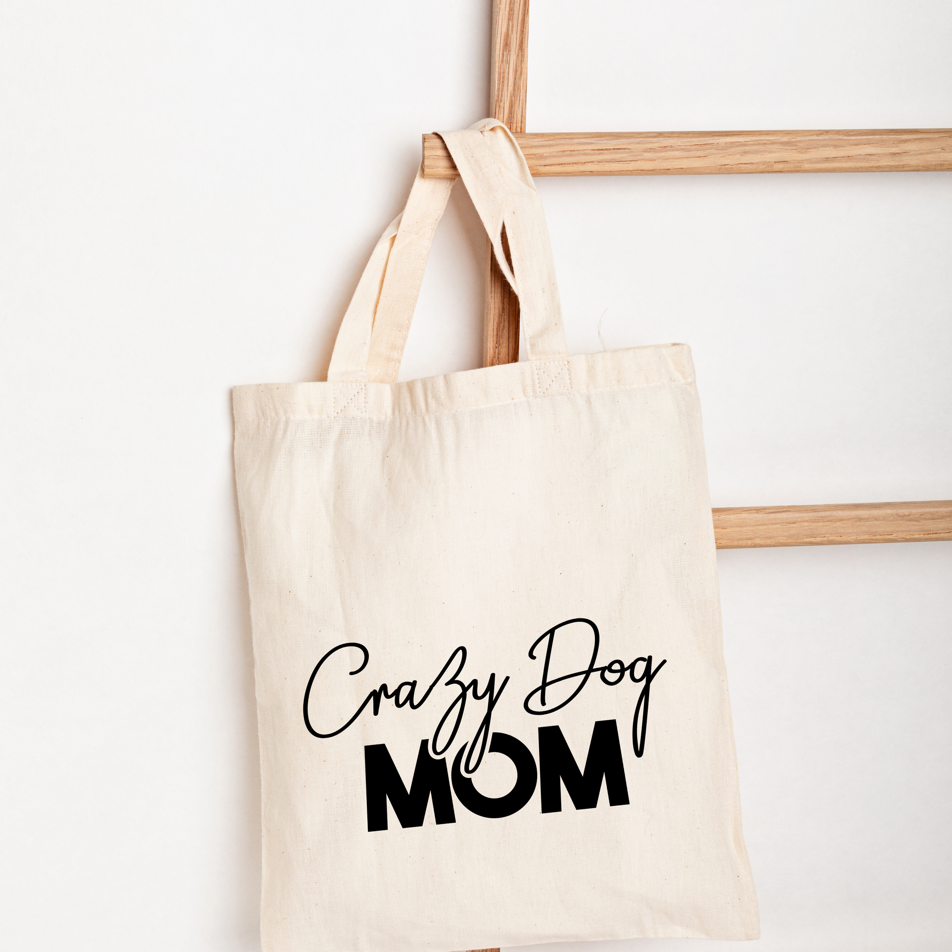 Beige tote bag with 'Crazy Dog Mom' text on a white background