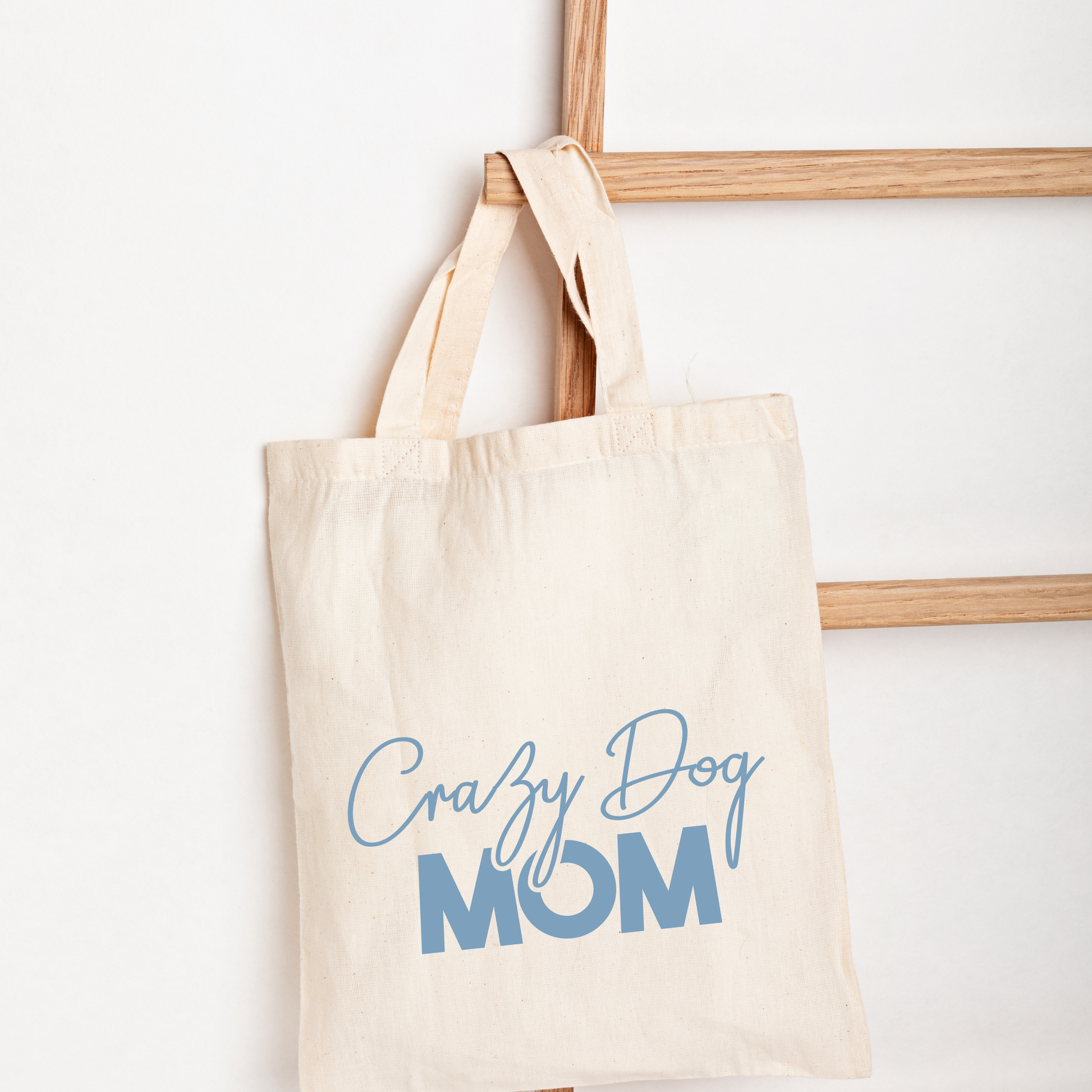 Beige tote bag with 'Crazy Dog Mom' text on a white background