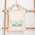 Tote bag with 'Crazy Dog Mom' text hanging on a wooden rack.