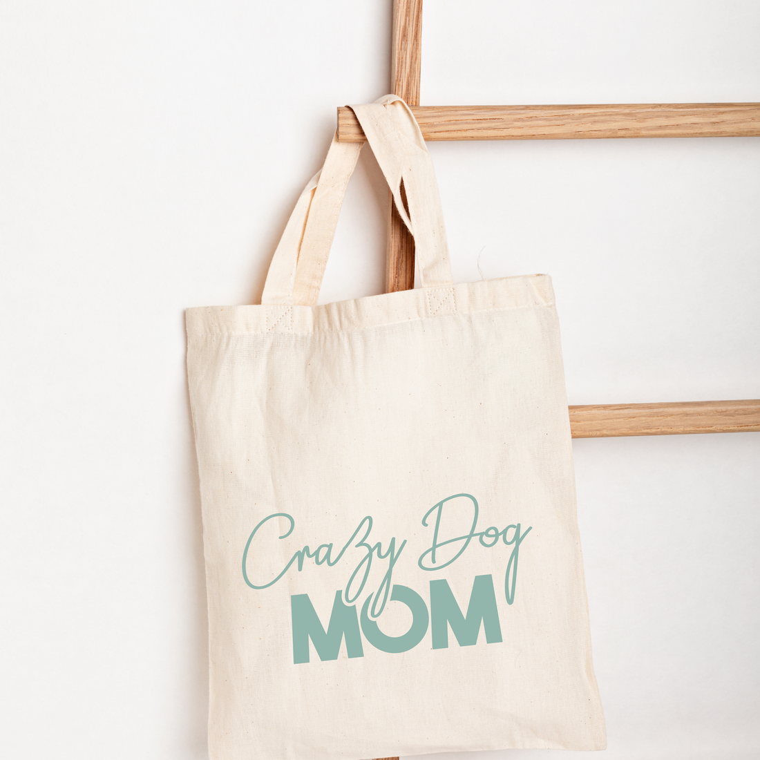 Beige tote bag with 'Crazy Dog Mom' text on a white background