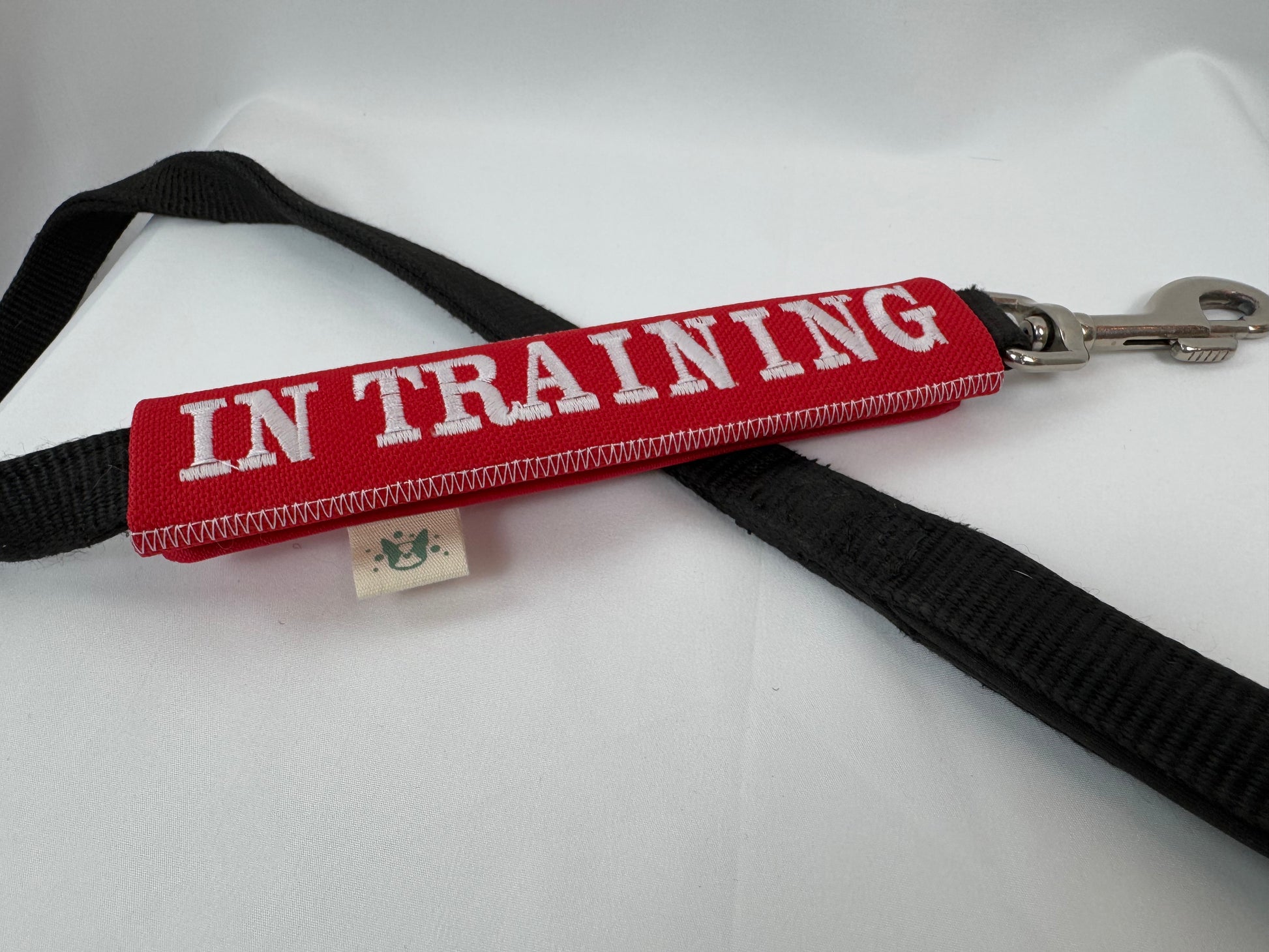 Red dog training collar with 'IN TRAINING' label on a white background
