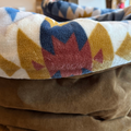 Close-up of a fabric with geometric pattern and brown material underneath