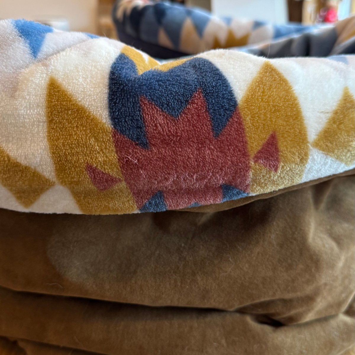 Close-up of a fabric with geometric pattern and brown material underneath