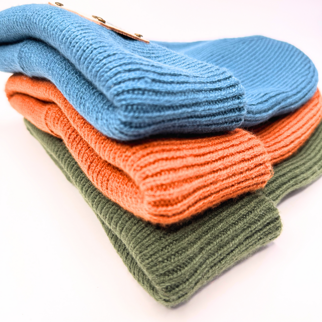 Green knit beanie with a brand label on a colorful background
