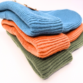 Stack of blue, orange, and green socks on a white background