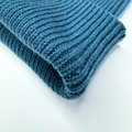 Folded blue knitted blanket on a white background