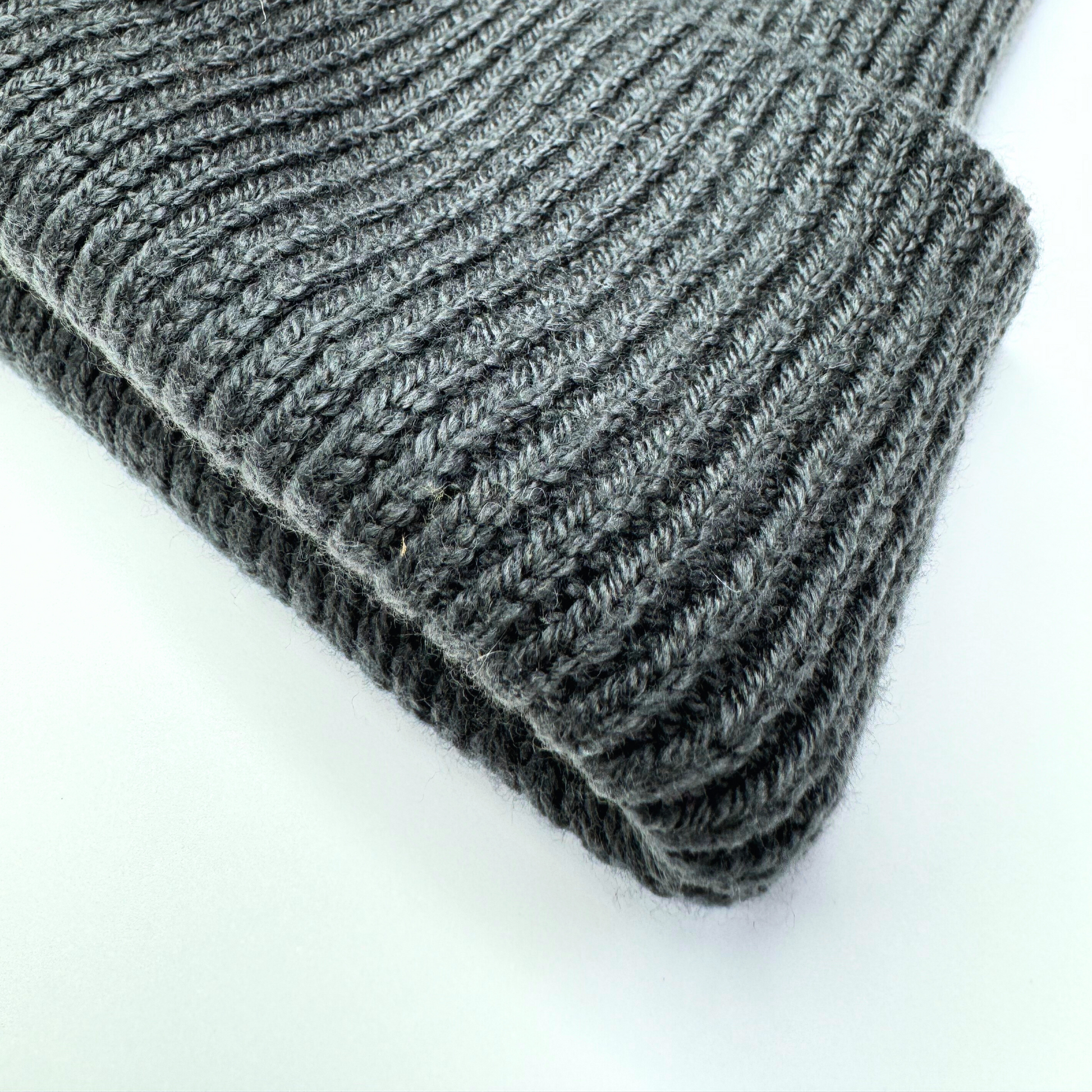 Stack of gray knit fabric on a white background