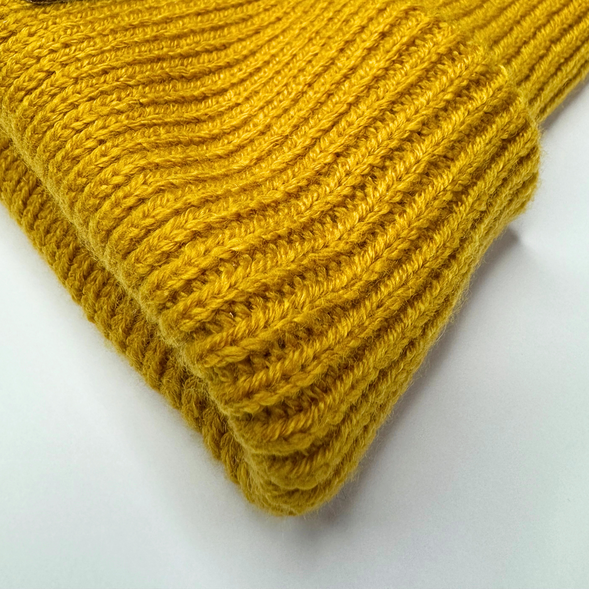 Close-up of a yellow knitted fabric on a white background