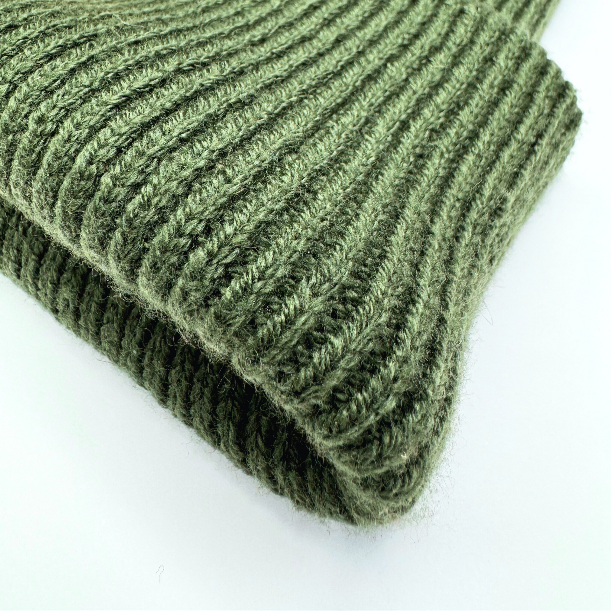 Folded green knitted fabric on a white background