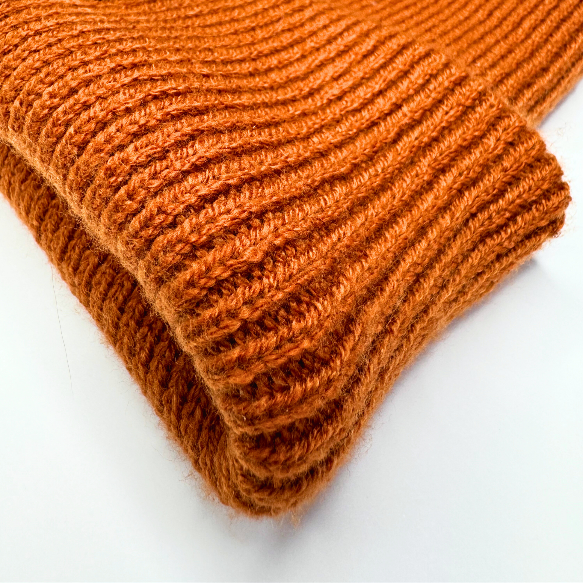 Stack of orange knitted fabric on a white background