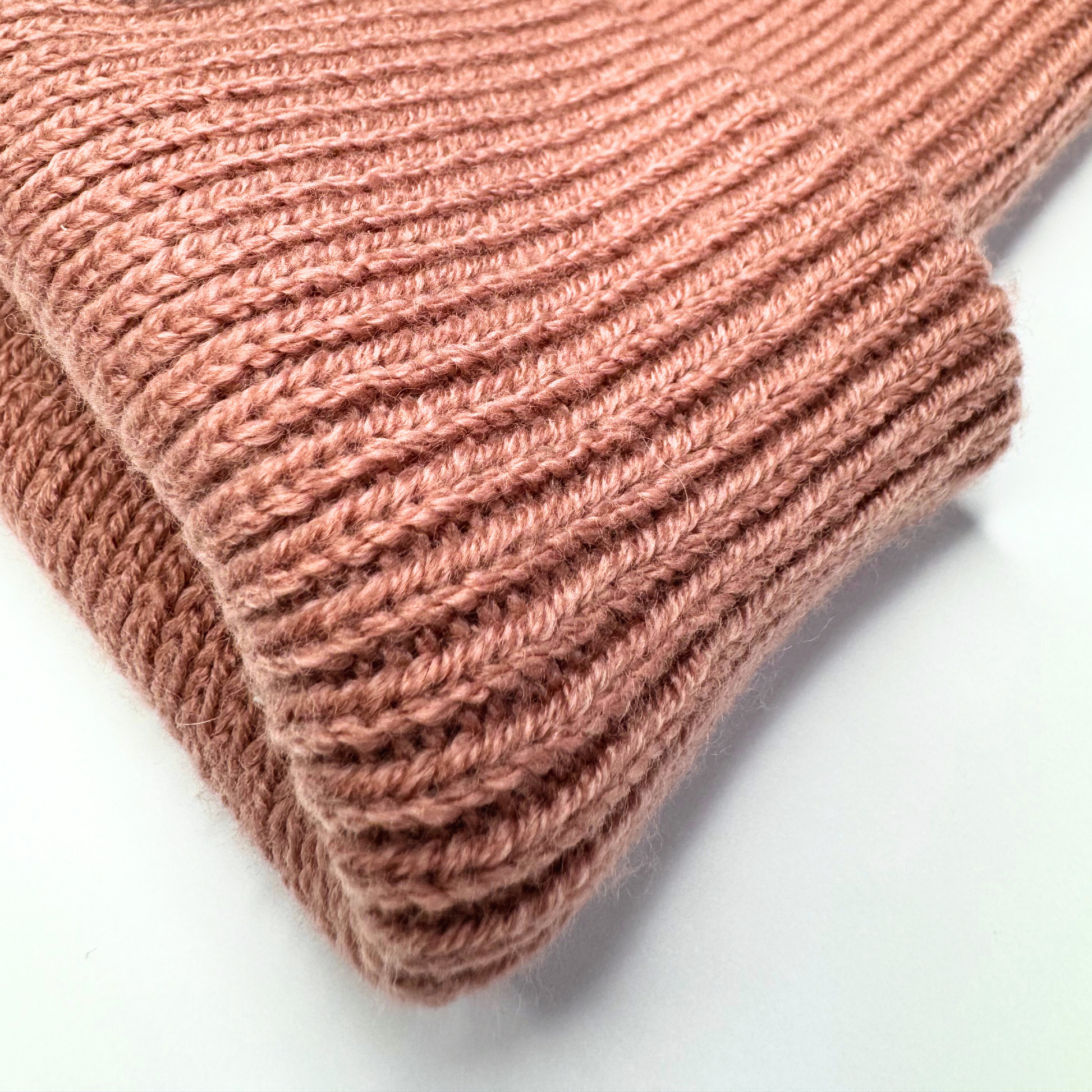 Close-up of a pink knitted fabric on a white background
