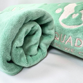 Folded green towel with 'Squad' text on a white background