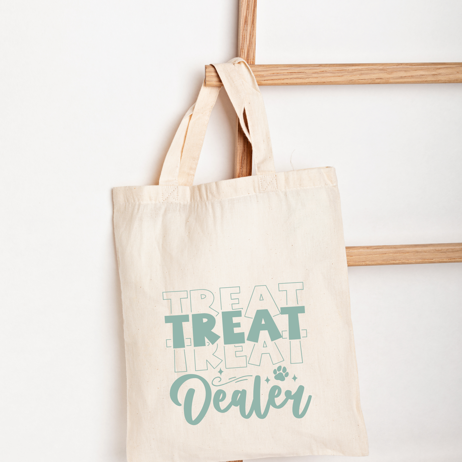Beige tote bag with 'Treat Treat Like a Cat Dealer' text on a white background
