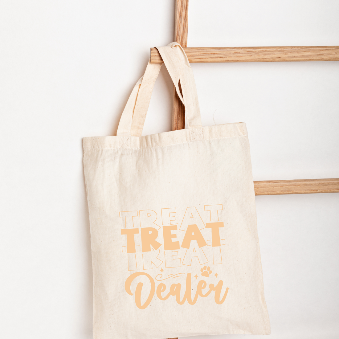 Beige tote bag with 'Treat Treat Like a Cat Dealer' text on a white background
