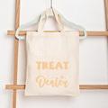 Tote bag with 'Treat Dealer' text on a wooden rack