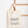 Beige tote bag with 'Treat Dealer' text on a white background