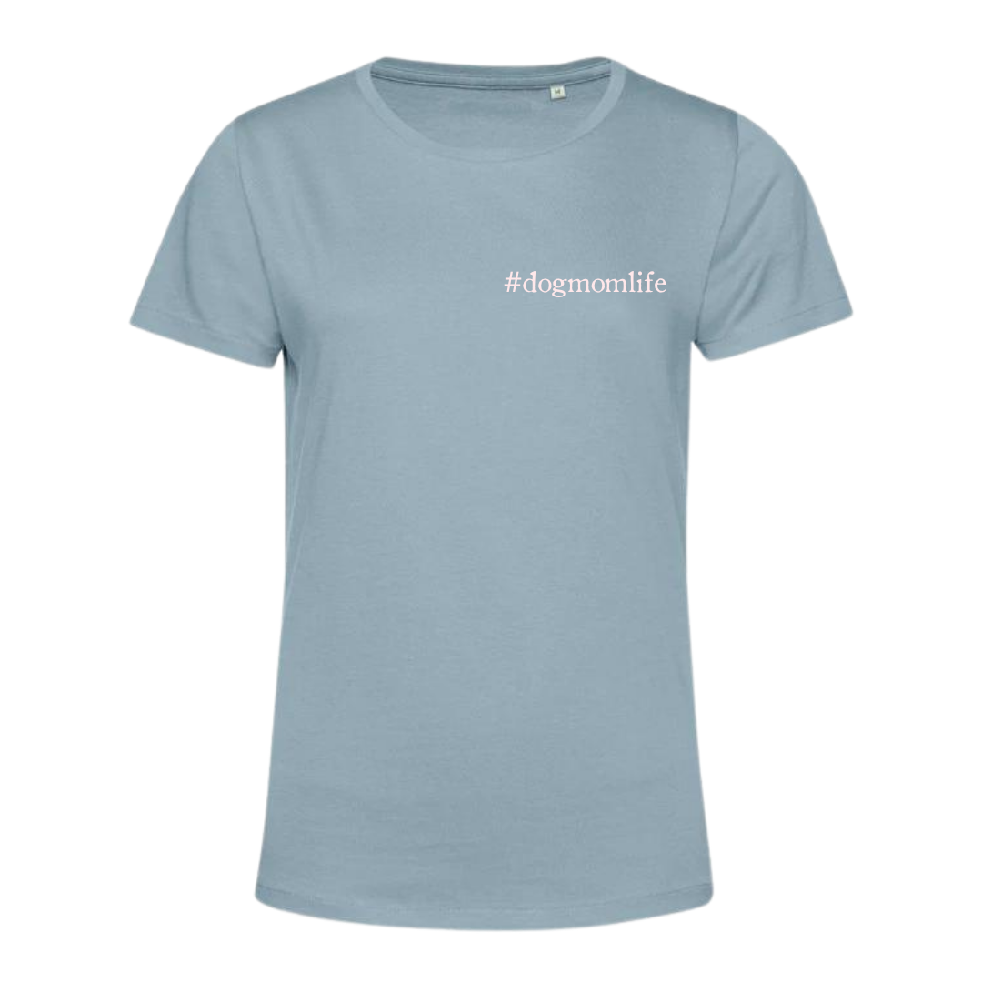 A light blue short-sleeve crewneck t-shirt with the text '#dogmomlife' printed in white on the left chest, displayed on a solid white background.