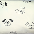 Off-white fabric with a repeating black line-art pattern of dog faces, shown close up.