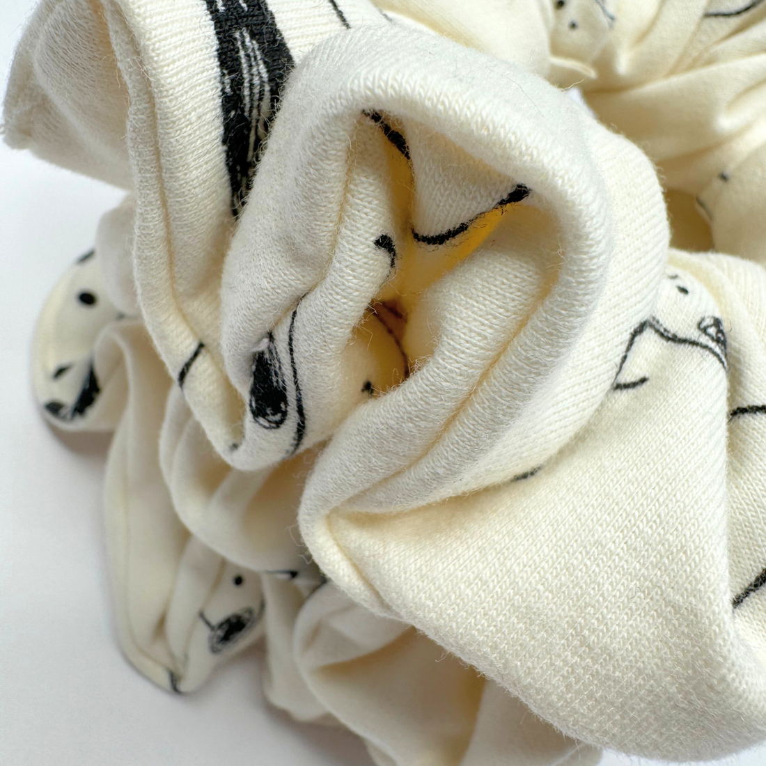White scrunchie with black patterns on a white background