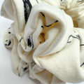 White scrunchie with black patterns on a white background
