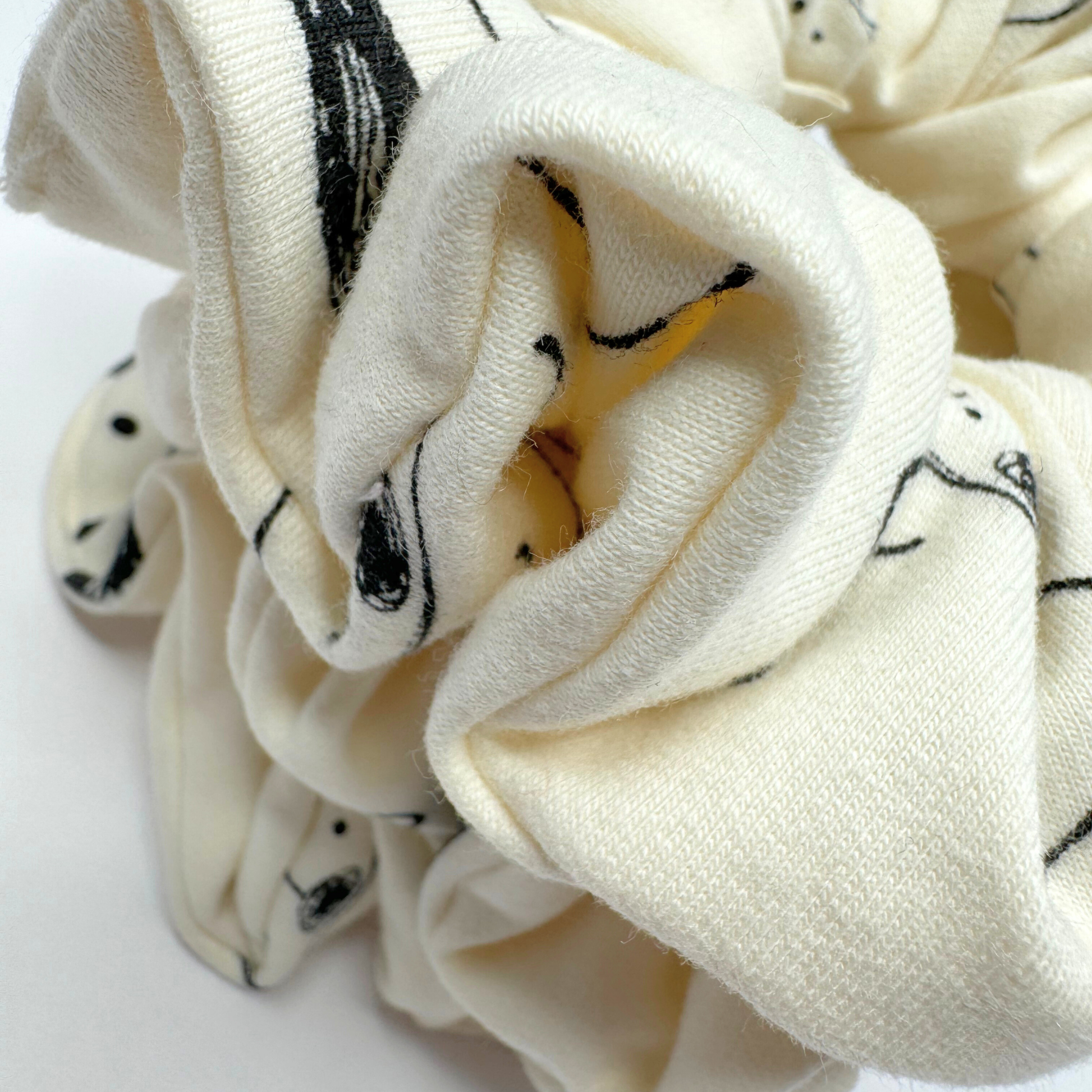 White scrunchie with black patterns on a white background