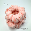 Pink fluffy scrunchie labeled 'Petit' on a light gray background