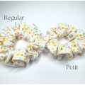 Two fabric scrunchies on a white background, labeled 'Regular' and 'Petit'. The scrunchies are off-white with a pattern of small pastel-colored polka dots in yellow, orange, and light blue.